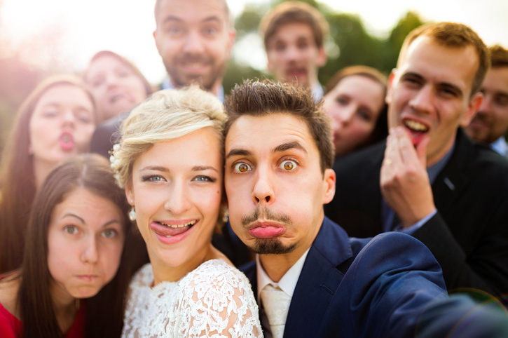 Newlyweds with friends taking selfie