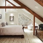 A free standing bath, roll top bed and exposed beams in this large and attractive bedroom at Devon Farmhouse