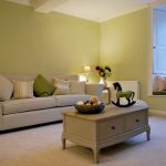 The sitting room with comfortable sofas, coffee table and large windows to the garden