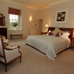 Bedroom 1 has a king size antique bed, elegant furniture and views over the garden.