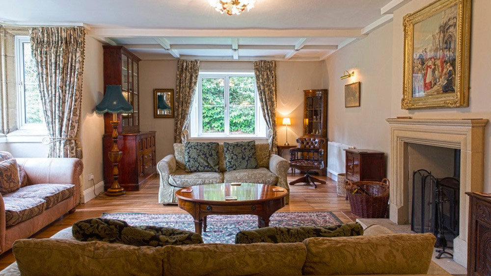 The light filled large sitting room has an open fire and comfortable sofas