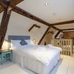 Bedroom 7 is a charming, cosy bedroom in the eaves, with wooden beams, painted floorboards and rugs
