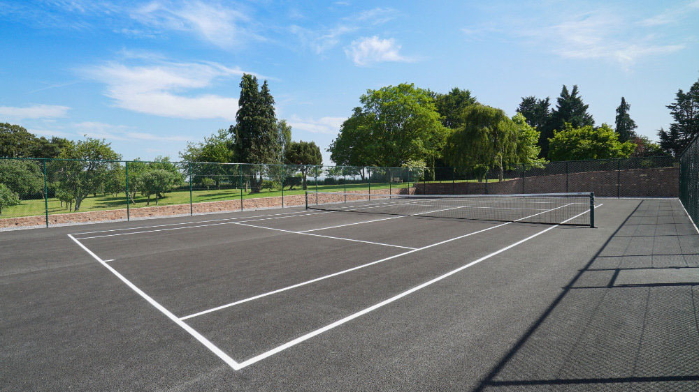 The tennis court at Tatham House is nestled beside the walled garden, overlooking the Quantocks