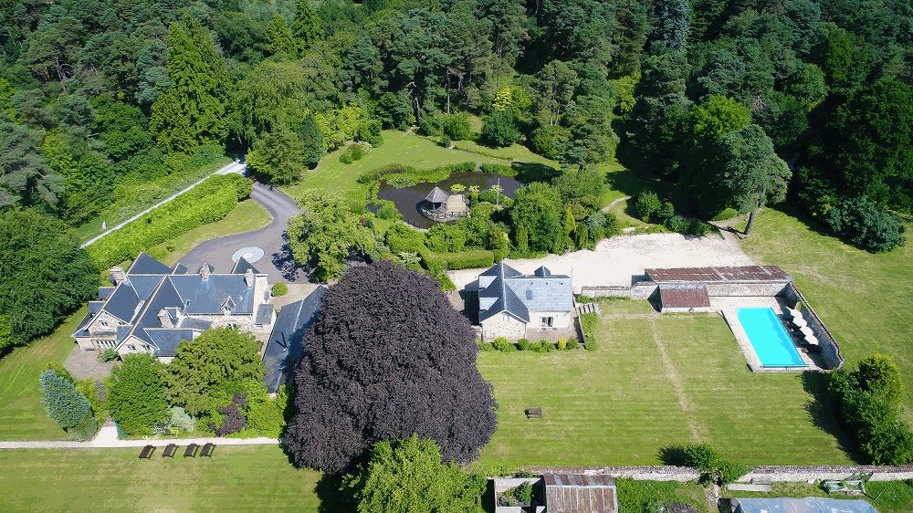 Aerial view of this big house in Somerset with outdoor pool and spacious grounds.