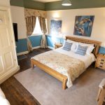 Shades of blue blend well in this bedroom with kingsize bed and sofa bed