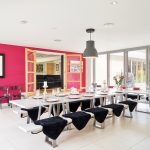 The trendy dining area with bi-fold doors which blend indoor/outdoor living on a summer day