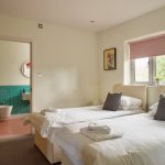 A calm and peaceful decor in Bedroom 2 with twin beds and ensuite bathroom
