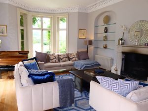 The elegant drawing room with log fire and views over the garden