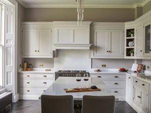 Modern kitchen at Bath Villa with white cabinetry, double oven and central island seating.