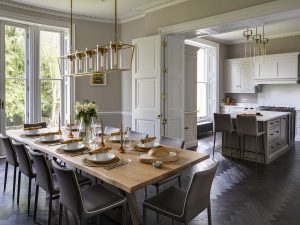 Open-plan kitchen and dining area at Bath Villa with large table, pendant lighting and garden views.