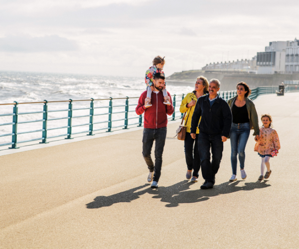 Family Holidays in Big Rentals exploring together A large family together by the sea having a walk on holiday
