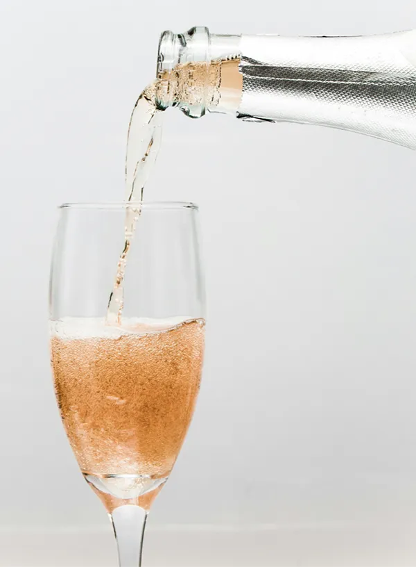 A bottle of champagne being poured into a glass