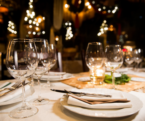 Planning a big family reunion 3 A large table set beautifully for dinner with white plates, wine glasses and candles. A family reunion dinner is a perfect way to get everyone together.